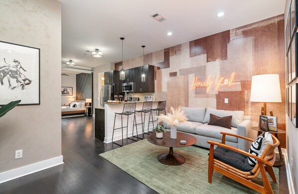 Bright and open-concept living area with designer furnishings, smart TV, and a sleeper sofa to accommodate additional guests.