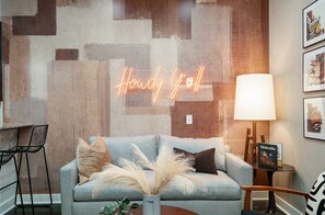 Bright and open-concept living area with designer furnishings, smart TV, and a sleeper sofa to accommodate additional guests.