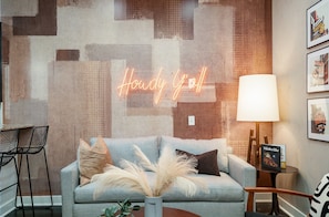Bright and open-concept living area with designer furnishings, smart TV, and a sleeper sofa to accommodate additional guests.