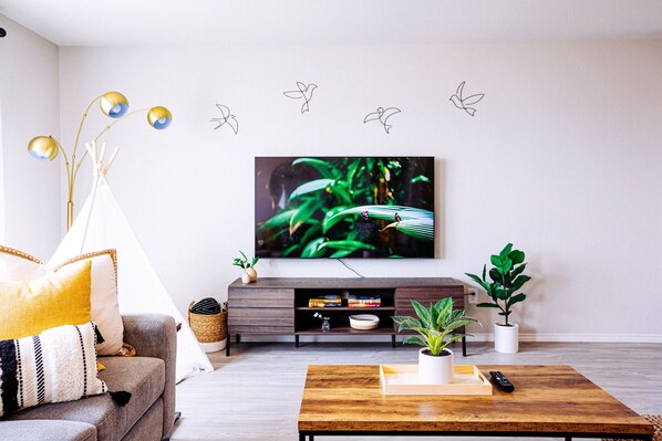 Bright and artful living room features family fun (65 inch TV, Teepee, sofa)