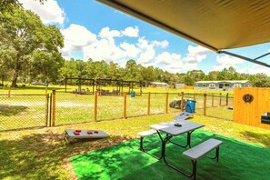 The Moto Ranch at Croom Vacation rental SX rv trailer. one bedroom 1 full bath sleeps 3.  outdoor living space, retractable awning, picnic table, comfy chairs, outdoor grill, gear tree, and hose