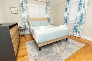 Bedroom 1: Queen-sized bed, 32" Smart TV, and Echo Dot