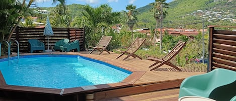 Espace piscine de 80 mètres carrés avec vue montagne , salon et chiliennes