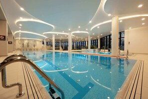 A luxurious indoor swimming pool with modern lighting and elegant design, ideal for relaxation.
