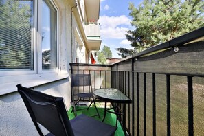 A small balcony with outdoor seating, offering a private space to enjoy the fresh air.

