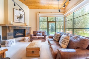 Spacious living area with flat screen TV, gas fireplace, vaulted ceiling and ample seating.