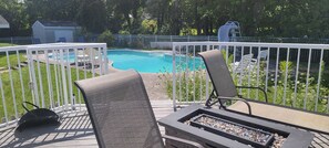 Waterfront deck by pool with gas firepit