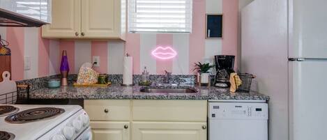 Discover this chic kitchen with playful pink stripes and vintage vibes, perfect for brunch in Nashville! Ideal for bachelorette parties and family reunions, this stylish rental blends comfort and sophistication. Create lasting memories here!