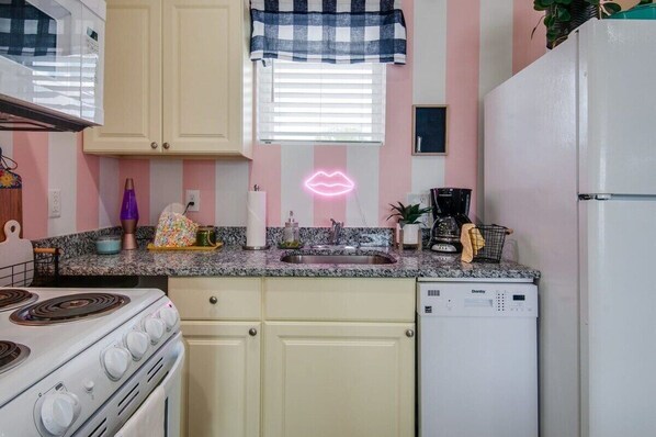 Discover this chic kitchen with playful pink stripes and vintage vibes, perfect for brunch in Nashville! Ideal for bachelorette parties and family reunions, this stylish rental blends comfort and sophistication. Create lasting memories here!