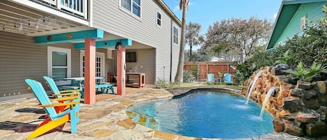 Spacious heated pool with waterfall .