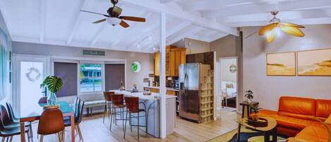 The inviting living room with plush sofas seamlessly blends into the spacious kitchen featuring a central island, creating an open and welcoming atmosphere for your stay.