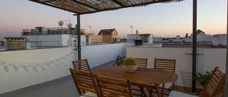 Large terrace with table chairs, gas barbecue and sun loungers.