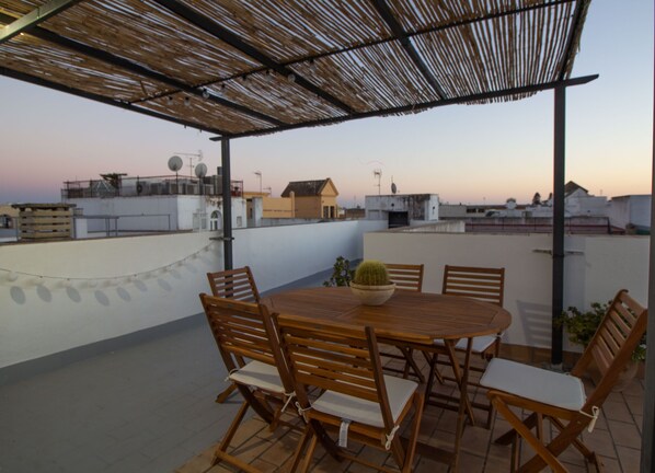 Large terrace with table chairs, gas barbecue and sun loungers.