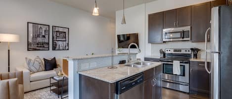 Fully equipped kitchen with stainless steel appliances, breakfast bar seating, and fully stocked with your basic cooking essentials.