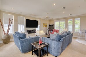 Second family room features comfortable seating, an arcade, and a dedicated bar area.