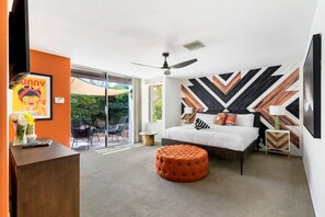 Vibrant Bedroom – Playful wallpaper, bright accents, and a serene outdoor view.
