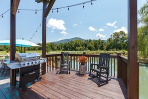 Outdoor Grill and patio seating overlooking mountain reflections on the water.