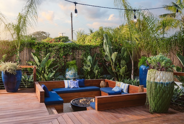 Romantic sunken firepit surrounded by lush tropical landscaping.