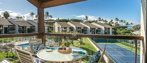 Private lanai with dining and views of the tennis courts, pool, and a peek a boo view of the ocean.