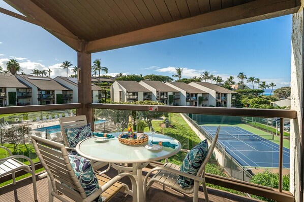 Private lanai with dining and views of the tennis courts, pool, and a peek a boo view of the ocean.