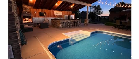 Outdoor heated pool with full kitchen and lounge area. 