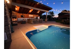 Outdoor heated pool with full kitchen and lounge area. 