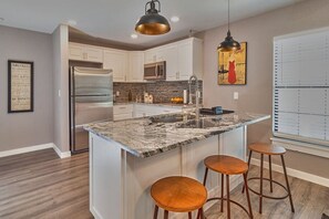 Brand new granite countertop kitchen with breakfast bar stools.