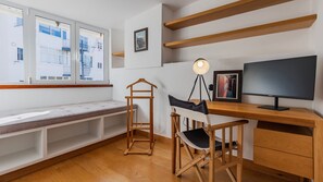 A well-lit study corner with a minimalist desk, comfy seating, and ample shelving, perfect for remote work. #WorkFromAnywhere #CreativeSpace