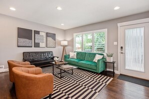 You will be greeted by an ultra-mod living space with a velvet green sofa sleeper, chestnut leather chairs and a retro leather couch.
