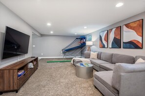 Welcome to the game room complete with a card table, giant connect 4, a collection of board games, putt-putt golf, basketball and a 65” Smart TV.