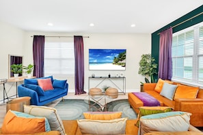 Our jewel toned living room boasts plenty of comfortable seating & a 75" TV