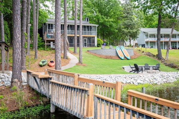 The backyard features a stamped concrete walking path, custom firepit, gazebo area (not pictured) and tanning area.