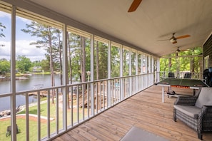 The upstairs patio features a couch and a chair for guests enjoying the views as well as a ping pong table. One step down from the patio is the propane grill for guests to use.