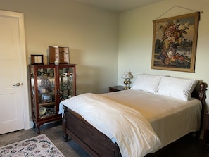 Bedroom with closet, queen bed, dresser and bedside tables.