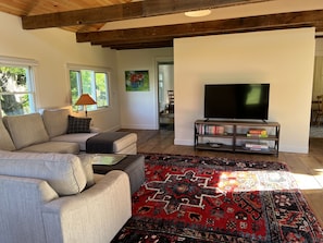 Entrance into the great room, smart TV, new L-shaped sofa with chaise lounge.  