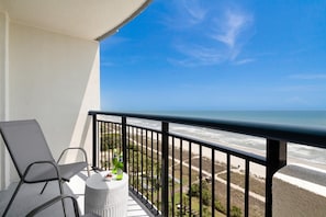 Step out onto your private balcony and soak in panoramic ocean views. With comfortable seating and a side table perfect for snacks or drinks, this serene spot invites you to unwind and enjoy the gentle sea breeze and the calming sound of the waves.