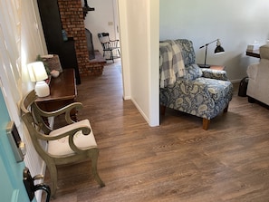 Entering the house, stairs on left, living room on right, fireplace & den ahead.