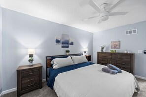 Serene bedroom with king bed, soft lighting, lighted mirror, and sound machine.