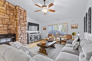 Comforable and spacious living room with Smart TV, dual fireplace, & ceiling fan