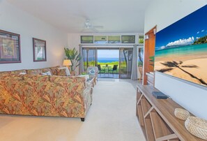 Your comfortable living room features a sleeper sofa, two sitting chairs, a coffee table, flatscreen TV, stereo, carpet and tile flooring and AC