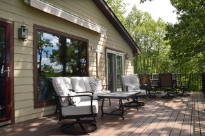 Relaxing deck with dining table and couch & swivel chairs.  