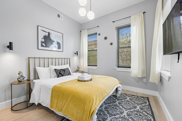 Relax in this sunlit bedroom featuring abundant natural light and a TV for your entertainment needs.
