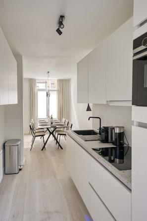 Open up the windows to illuminate the space with natural light in this open concept dining room/kitchen area.