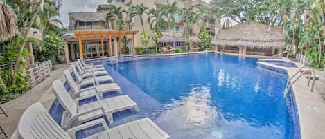 Large pool area with lounge chairs and seating areas.