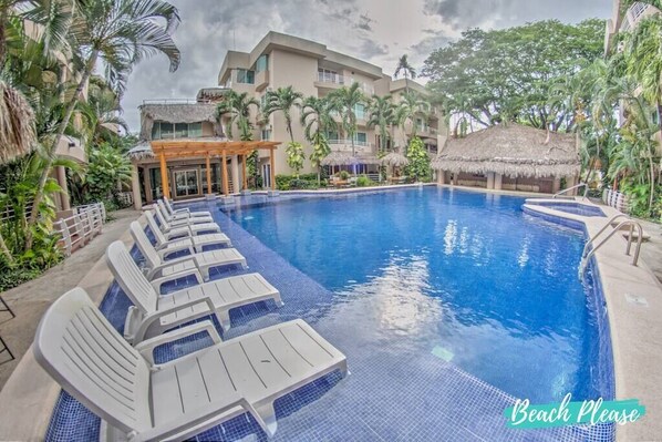 Large pool area with lounge chairs and seating areas.