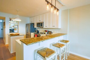 The kitchen features white cabinetry, granite counters and stainless steel appliances.