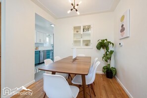 The dining table is set for 6 with additional seating in the kitchen