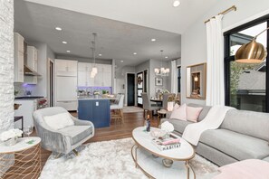 Living Room with plush sectional sofa, contemporary arm chairs, smart tv, gas fireplace, and private deck access