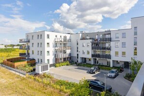 An exterior view of the residential complex, highlighting modern architecture and green surroundings.