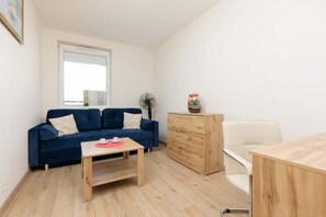 A view of the second bedroom with a sofa bed and a desk perfect for remote work.